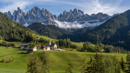 The Santa Magdalena church in the Dolomites with in the backgrpound the famous Geisler mountains, taken during sunset in autumn.の写真素材