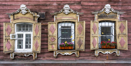 Russian old red log cabin with pink and yellow shutters in Irkutsk, Russia.の写真素材