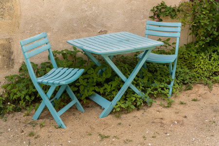 Blue wooden chairs and blue table on the sand.の写真素材
