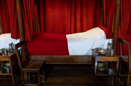 Buaune, France - July 2, 2020: Interior with beds and red blankets of hospice and museum l'Hotel-Dieu, in Beaune, Franceのeditorial素材