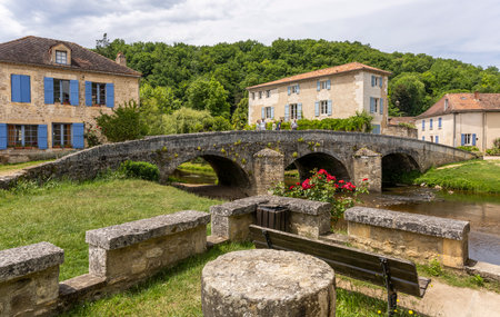 Saint-Jean-de-Cole, France - June 12, 2022: Small river La Cole with old bridge and people in the village of Saint-Jean-de-Cole one of the 'Plus beaux village de France'.のeditorial素材