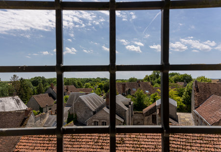 Yevre-le-Chatel, France - June 15, 2022: Small village of Yevre-le-Chatel, one of the 'Plus Beaux Villages de France', view from the fortress through a window with bars.のeditorial素材
