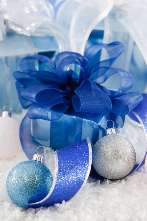 Cool blue, white and silver wrapping paper and ribbon make a fresh and frosty holiday scene with presents nestled in snow, accented with ribbon and glittery ornaments.の写真素材