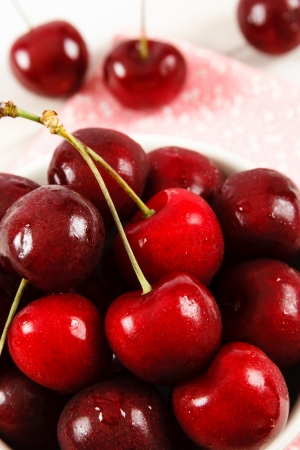 Close up of freshly washed ripe red cherries piled in a bowlの写真素材