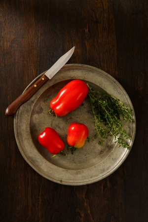 Overhead view of ripe, red plum tomatoes on a rustic pewter plate accented with Thyme   Copy space above and below の写真素材