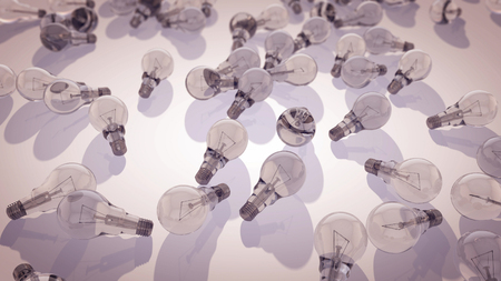 A multilayered 3d rendering of transparent light bulbs placed on a grey surface. The fluorescent light bulbs are lit and have curvy metallic spirals inside. They symbolize the consumer society.  の写真素材