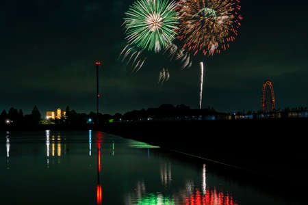 Fireworks on Black background in the japan summer season nighttime. Reflate lake water with colourful.の写真素材
