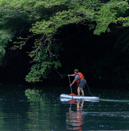 Okutama, Tokyo Japan - 05 28 2022: Deep green water lake kayaking with safety . water sports, red...