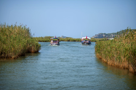 TURKEY, DALYAN, MUGLA - JULY 19, 2014: Touristic River Boats with tourists in the mouth of the Dalyan Riverのeditorial素材