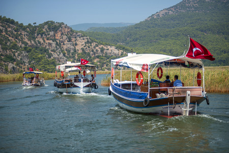 TURKEY, DALYAN, MUGLA - JULY 19, 2014: Touristic River Boats with tourists in the mouth of the Dalyan Riverのeditorial素材