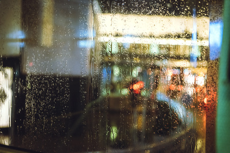 Wet with rain street through the glass of the bus.の写真素材