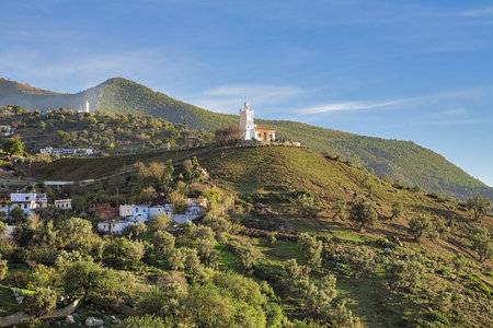 Jemaa Bouzafar, a small 15th century mosque on a hill above the town of Chefchaouen in the Rif mountains of North West Morocco at the end of sunny dayの写真素材