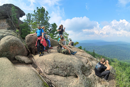 KRASNOYARSK, RUSSIA - AUGUST 16, 2016. Unidentified hikers on the top of Ded rock (Grandfather rock) in the Stolby Nature Sanctuary. Stolby is the world famous nature reserve with complexes of rocks.のeditorial素材