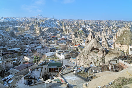 Goreme town in Cappadocia in winter, Turkey. The Uchisar Castle Rock is visible in the background in the mist.のeditorial素材