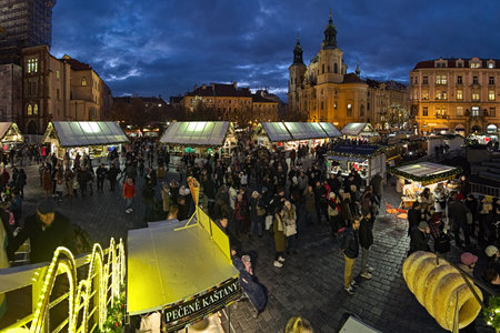 PRAGUE, CZECH REPUBLIC - DECEMBER 5, 2017: Christmas market at the Old Town Square in twilight. Unknown people walk around the market stalls. St. Nicholas Church is located at the square corner.のeditorial素材