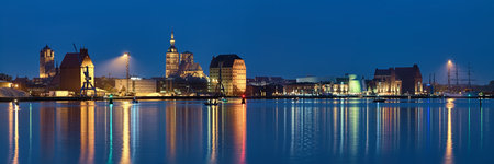 Stralsund, Germany. Panoramic view of the North Harbor in dusk with St James Church (left), St Nicholas Church (center), oceanic museum, historical warehouses and the Gorch Fock museum barque (right).のeditorial素材