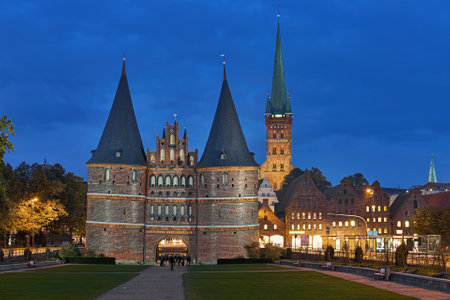 Lubeck, Germany. Holstentor (Holsten Gate), tower of St. Peter's Church and Salt storehouses in dusk. The gate was built in 1464. Latin inscription on the gate reads: Harmony at home and Peace abroad.のeditorial素材