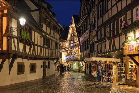 STRASBOURG, FRANCE - DECEMBER 15, 2019: Rue du Bain-aux-Plantes street in Petite France historic quarter in dusk with half-timbered houses decorated for Christmas.のeditorial素材
