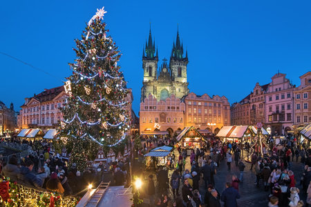 PRAGUE, CZECH REPUBLIC - DECEMBER 11, 2019: Panoramic view of Christmas market at Old Town Square with city's main Christmas tree in twilight. Church of Our Lady before Tyn is located in background.のeditorial素材