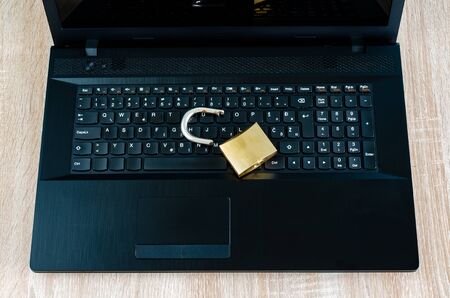 Broken padlock on open laptop computer, concept for Internet and technology security breach or data theftの写真素材