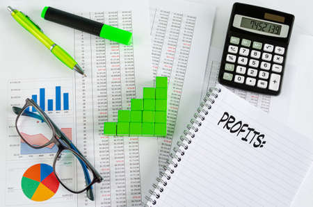 Financial documents, with green cubes arranged in a column graph as a concept for increasing profitsの写真素材