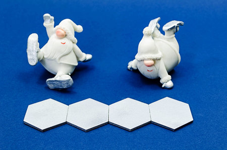 Silver wooden hexagons with copy space and two christmas dwarfs in conceptual image of the coming...