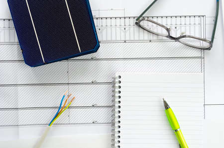 Top view of solar cells, notepad, pen, eyeglasses and electrical cable as a concept of planning for photo voltaic projectの写真素材