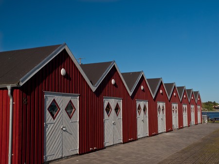 Small red huts for storing fishing equipment in marina. の写真素材