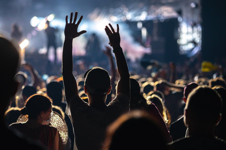 Raised hands in honor of a musical show on stage, People in the hallのeditorial素材