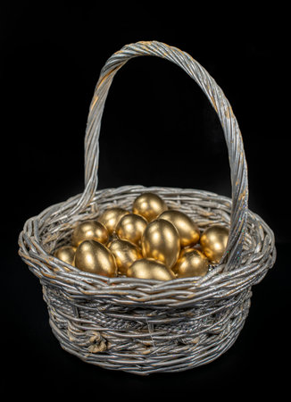 Golden eggs lie in a silver basket, close-up.の写真素材
