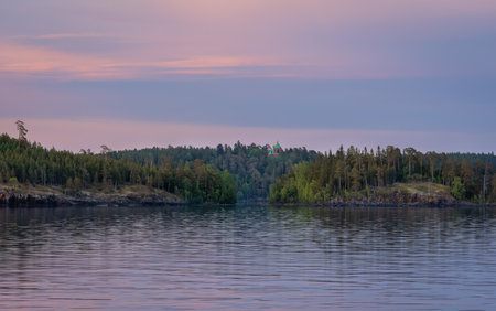 Valaam island with a barely noticeable dome of the monastery in the middle of the forest in the evening twilight at sunsetの写真素材