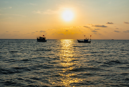 Fishing boats under the flag of Vietnam in the South Sea against the sunsetの写真素材