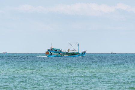 A fishing boat under the flag of Vietnam sails across the sea to the fishing spotの写真素材