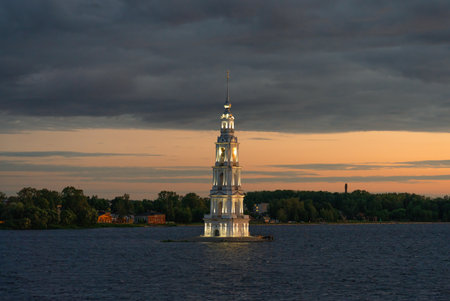 The Kalyazin bell tower is a flooded church illuminated at night against the background of sunsetの写真素材