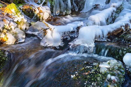 Thawed streams of a frozen waterfall close-upの写真素材