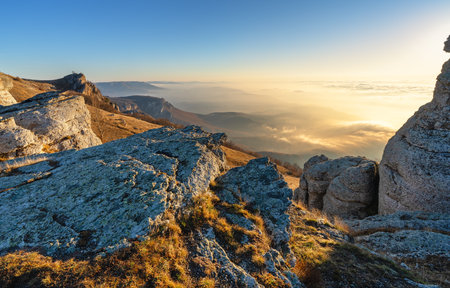 A bright sunrise among the rocks on a mountain peakの写真素材