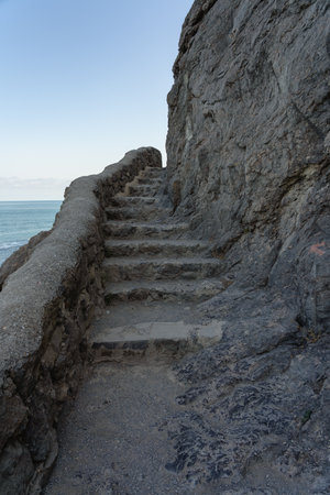 Ancient steps carved into a cliff by the coastの写真素材