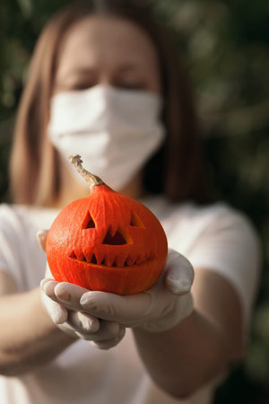 Halloween concept, autumn, coronavirus protection.Defocused woman in medical mask and rubber gloves...