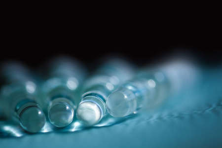 Blurry medical background. Ampoules with medicine. Medical concept.Abstract black and blue background.Coppy spice.の写真素材