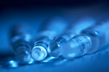 Four ampoules of medicine in a blurry form. Blue ampoules. Blue-blue medical background.Coppy spiceの写真素材