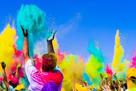 crowd throws colored powder at holi festivalの写真素材