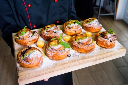 chef holding fresh homemade bakery with berries and toppingの写真素材