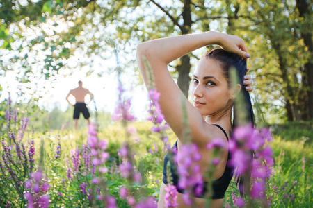 Beautiful fit young woman in sporty outfit in green tall grass. Healthy and active lifestyle,の写真素材