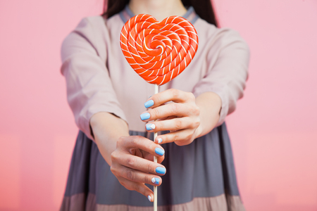 Young woman with heart candy lollipop. Love concept.の写真素材