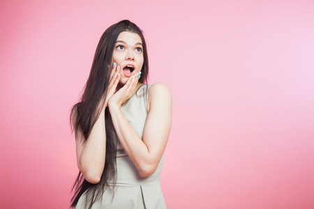 Young brunette girl expression of surprise excitement copy space pink background studioの写真素材