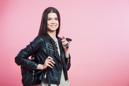 Young woman in leather jacket, bag and car keys. Confident girl ready to drive her car or motobike.の写真素材