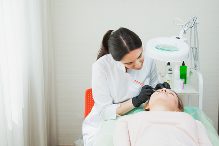 Process of applying permanent makeup tattoo pen machineの写真素材