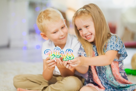 Children boy and girl holding new year 2018. Brother and sister playing with christmas decoration. Happy family conceptの写真素材