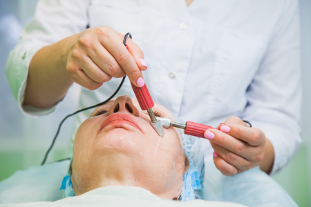 muscle toning procedure for senior woman in cosmetology clinic, beauty salon. Female patient enjoys skin care treatment.の写真素材