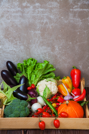 Fresh autumn vegetables in wooden box organic food concept. harvest raw eating healthy diet background copy space verticalの写真素材